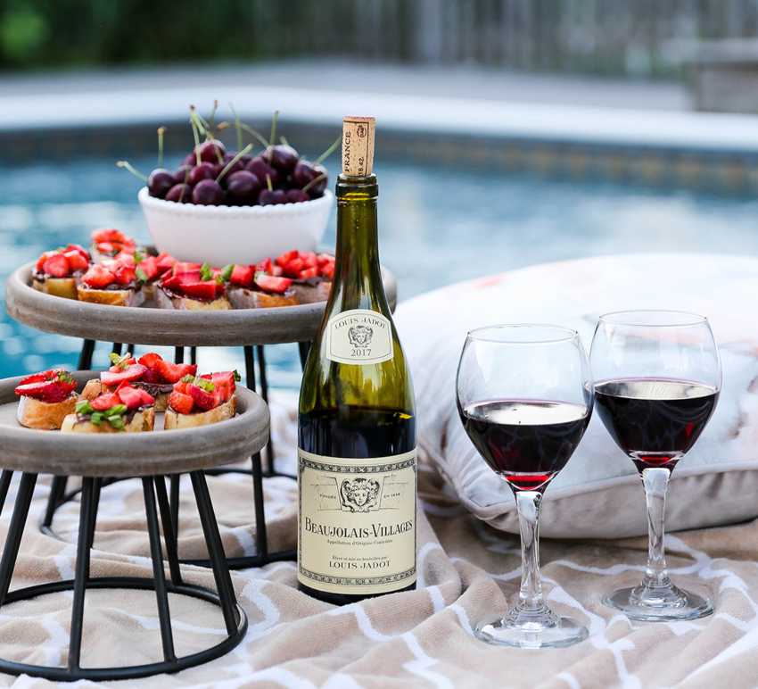 Red French wine by the pool with cherries and bruschetta